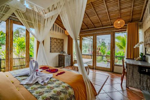 a bedroom with a bed with a mosquito net at Sacred Padi Ubud Villa in Payangan
