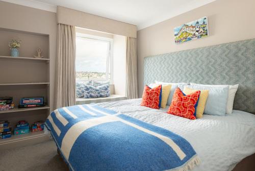 a bedroom with a large bed with colorful pillows at 3 Bed Stylish Beachfront Retreat in Roche