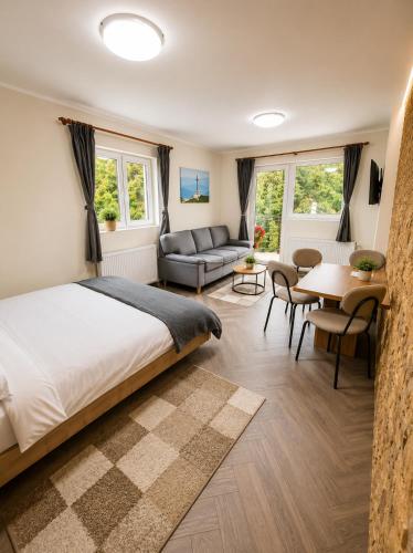 a bedroom with a bed and a couch and a table at Vila Monica in Buşteni