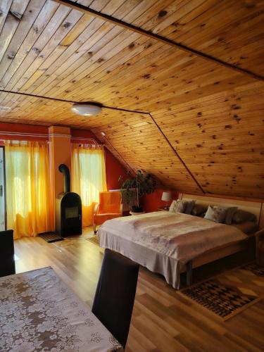 a bedroom with a bed and a wooden ceiling at Őrségi Lápréti Vendégház in Szőce