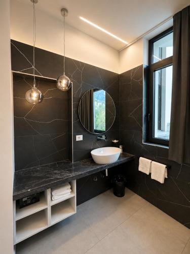 a bathroom with a sink and a mirror at Athos Hotel in Riva del Garda