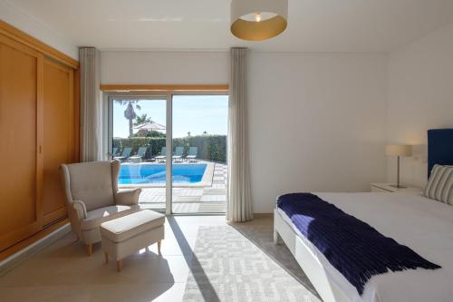a bedroom with a bed and a chair and a patio at Marvellous Villa in Óbidos