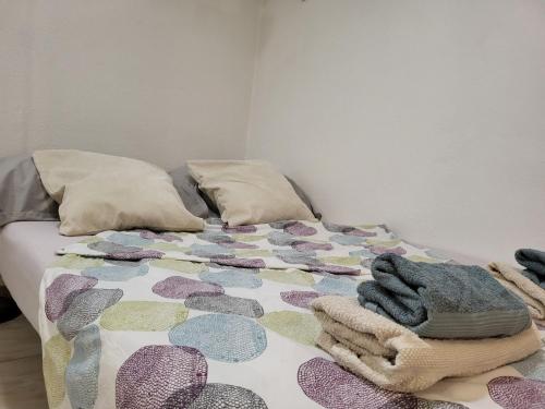 a bed with a colorful blanket and pillows on it at Apartma Oliva in Koper