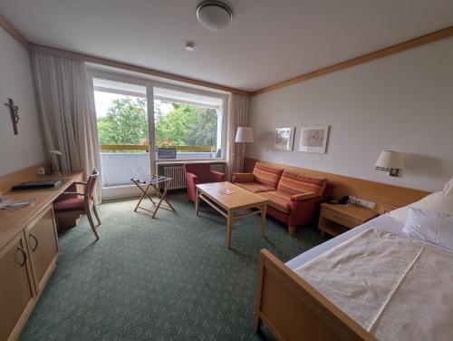 a hotel room with a bed and a living room at Kneippkurhaus St Josef in Bad Wörishofen