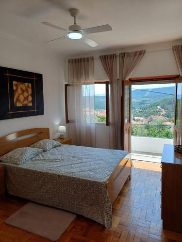 a bedroom with a bed and a large window at Serra Viva in Cortes do Meio