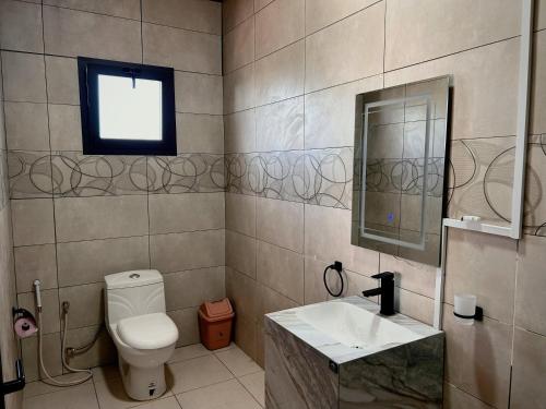a bathroom with a toilet and a sink and a window at Belvédère Hôtel in Toliara