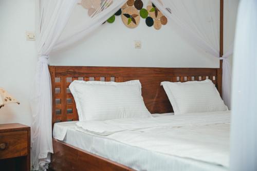 a bedroom with a bed with white sheets and white pillows at Belvédère Hôtel in Toliara