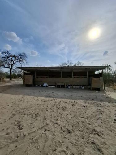 a building sitting in the middle of a dirt field at Hennies HideOut in Kachikau