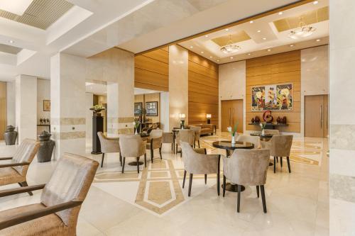 a lobby of a hotel with tables and chairs at Divani Palace Larissa in Larisa