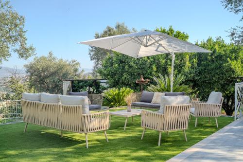 a patio with four chairs and an umbrella at Grania Le Radici - Agriresort in Gragnano