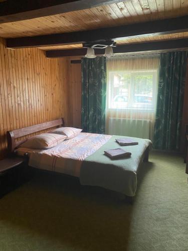 a bedroom with a large bed with a window at Шепіт Лісу in Yaremche
