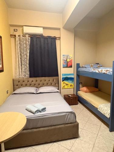 a bedroom with a bed and two bunk beds at Hotel Bar Restaurant Riviera in Shëngjin