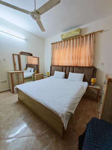 a bedroom with a large white bed and a mirror at Luxury Apartment in Aqaba in Aqaba