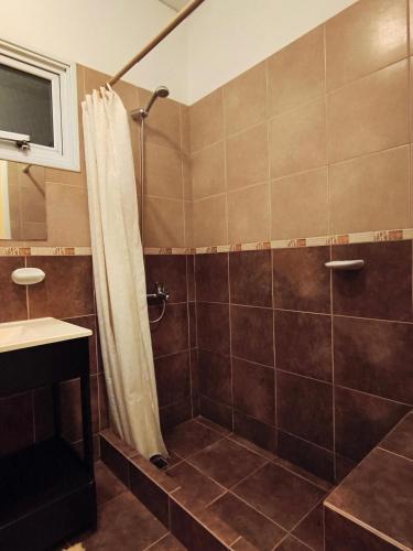 a bathroom with a shower with a shower curtain at Casa Valdés in Puerto Pirámides