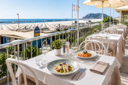 a table with two plates of food on a balcony at Hotel Caravelle - Nuova Gestione 2026 in Cattolica