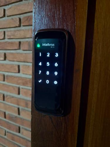 a remote control on a wooden door at Suíte com Ar condicionado no Centro de Botucatu in Botucatu