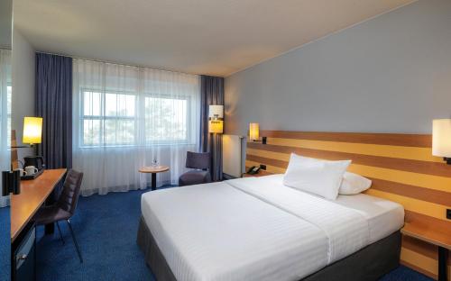 a hotel room with a bed and a desk at IntercityHotel Frankfurt Airport Terminal 3 in Frankfurt