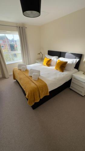 a bedroom with a large bed with yellow pillows at Hunters Wharf River View by Select SA in Reading