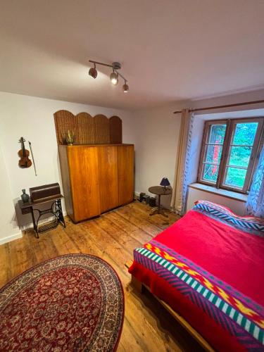 a bedroom with a red bed and a wooden floor at Pod Lasem in Zwierzyniec