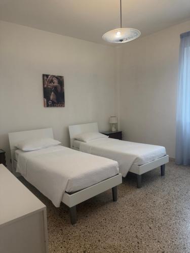 a hospital room with two beds and a chandelier at Via Clitunno 24 in Foligno