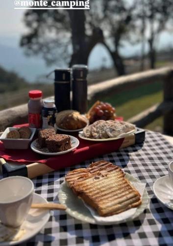 a table with plates of food on a checkered table cloth at Chalés Refúgio nas montanhas in Guaratuba