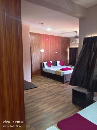 a hotel room with a bed with red pillows at Hotel Tamilnadu-Unit 2 in Rāmeswaram