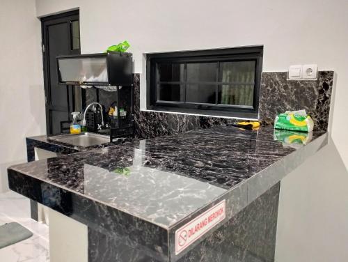 a kitchen with a granite counter top and a sink at Hasbi Homestay Syariah in Bukittinggi