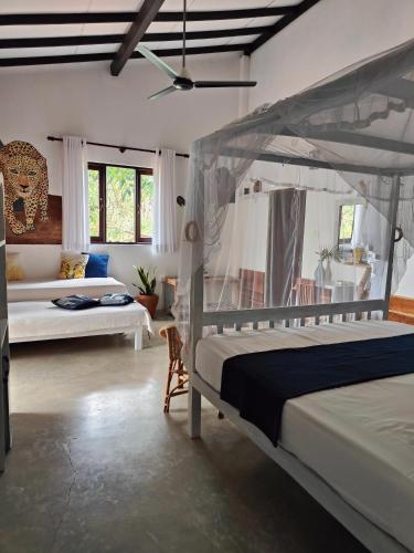 a bedroom with two beds and a ceiling fan at Villa Lyvie ayurvedic hotel in Tangalle