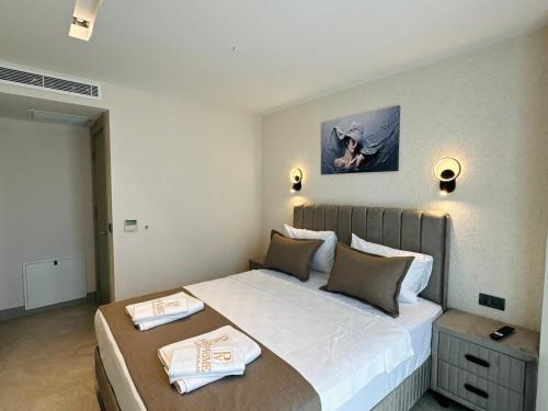 a bedroom with a large bed with two towels on it at Prime Bodrum Villas in Bodrum City