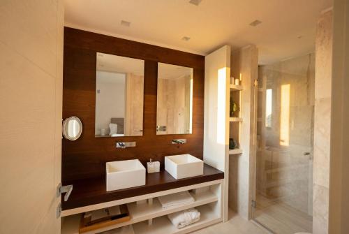 a bathroom with a sink and a mirror and a shower at La Tiara di Cervo in Porto Cervo