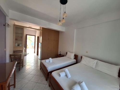 a room with two beds and a table and a kitchen at Kallisti in Finikounta