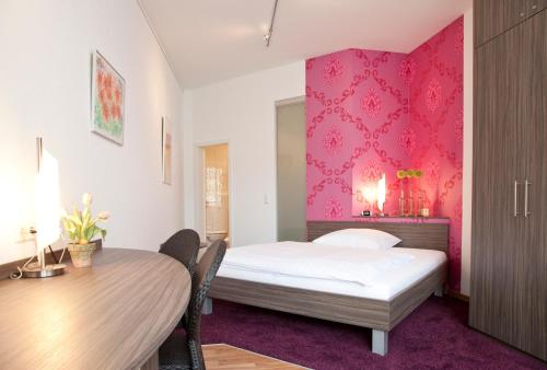 
a bedroom with a bed and a desk at B&B Appartements in Tuttlingen
