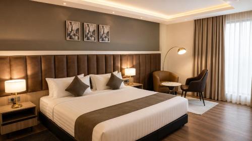 a hotel room with a large bed and chairs at Ras Hotel - Harar in Hārer