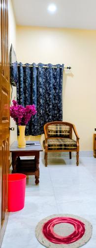 a living room with a couch and a table with flowers at Ratnadeep Palace - Near Kashi Vishwanath Temple & Ghats in Varanasi