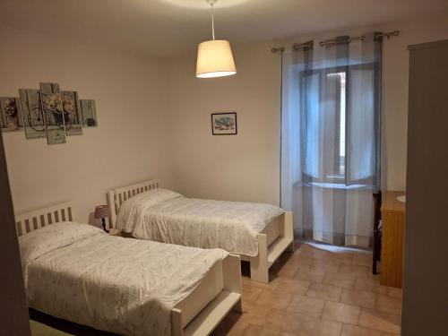 a bedroom with two beds and a window at Appartamento Felis in Molina di Ledro