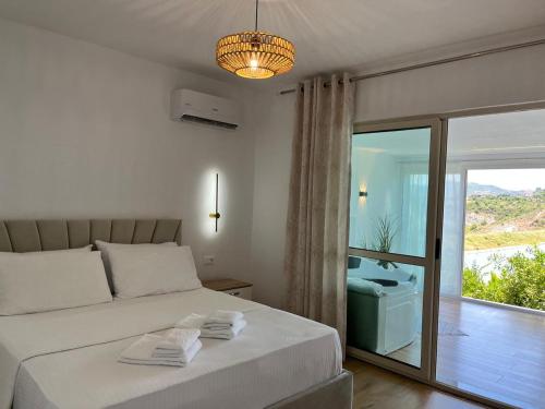 a bedroom with a bed and a window with a view at Lake Breeze in Gjokaj