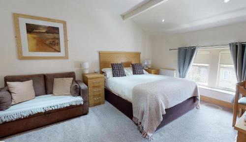 a bedroom with a bed and a couch at The Horse & Farrier in Otley