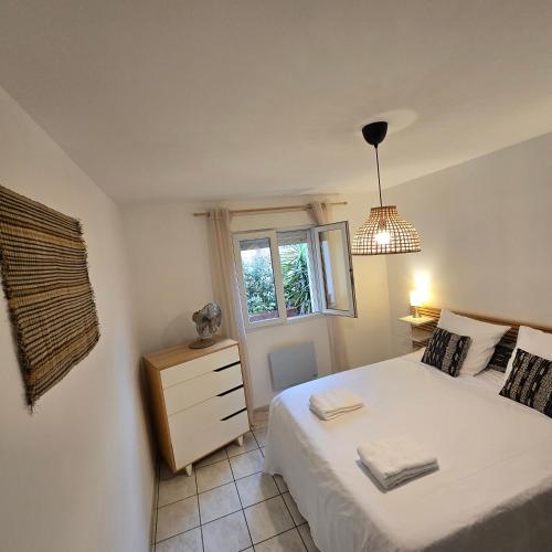 a small bedroom with a bed and a window at Maison Lauret in Agde