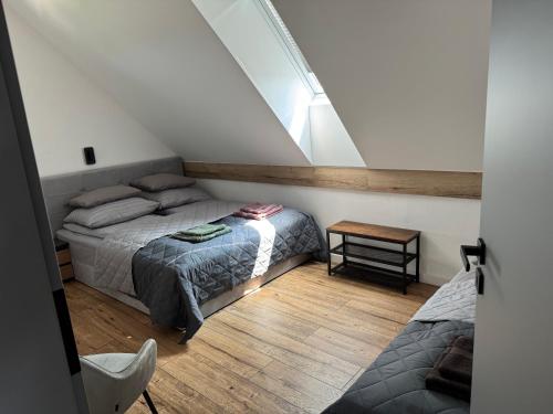 a attic bedroom with two beds and a table at Dom z Widokiem in Łączonek