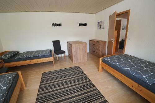 a room with two beds and a chair in it at IBS Wohnen in Windischeschenbach