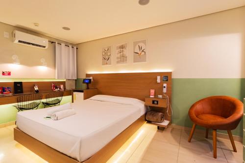 a bedroom with a bed and a chair in it at Spa Motel - Radial Leste in São Paulo