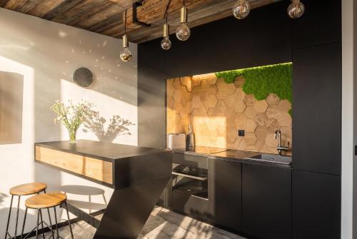 a kitchen with black counters and a wooden wall at come home - bespoke villa in Kościelisko
