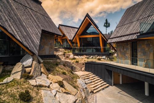 a house on a rocky hillside with a roof at come home - bespoke villa in Kościelisko