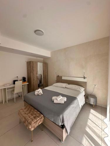 a bedroom with a large bed with towels on it at D&F Guest House in Milazzo
