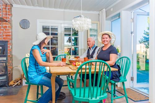 three people sitting at a table in a dining room at Strandheimen Guesthouse in Melhus