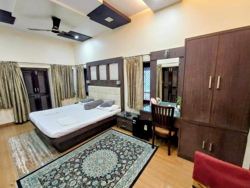 a bedroom with a bed and a desk and a chair at Hotel Alka in Varanasi