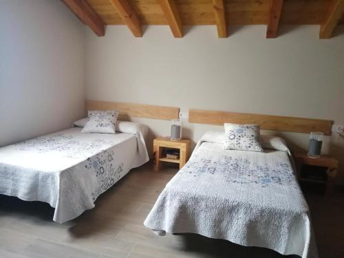 a bedroom with two beds and a wooden ceiling at Argixti in Sumbilla