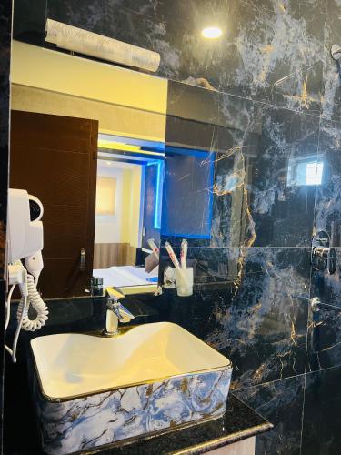 a bathroom with a yellow sink and a mirror at Pine Tree Resort in Nagarkot