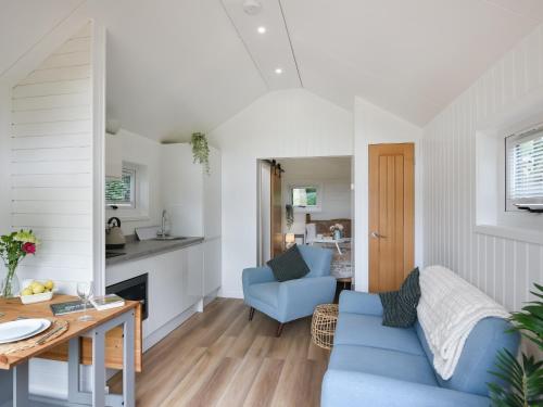 a living room with a blue couch and a table at Mini Lodge - Uk47682 in Montgomery