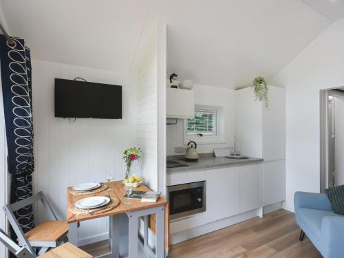 a small living room with a table and a kitchen at Mini Lodge - Uk47682 in Montgomery